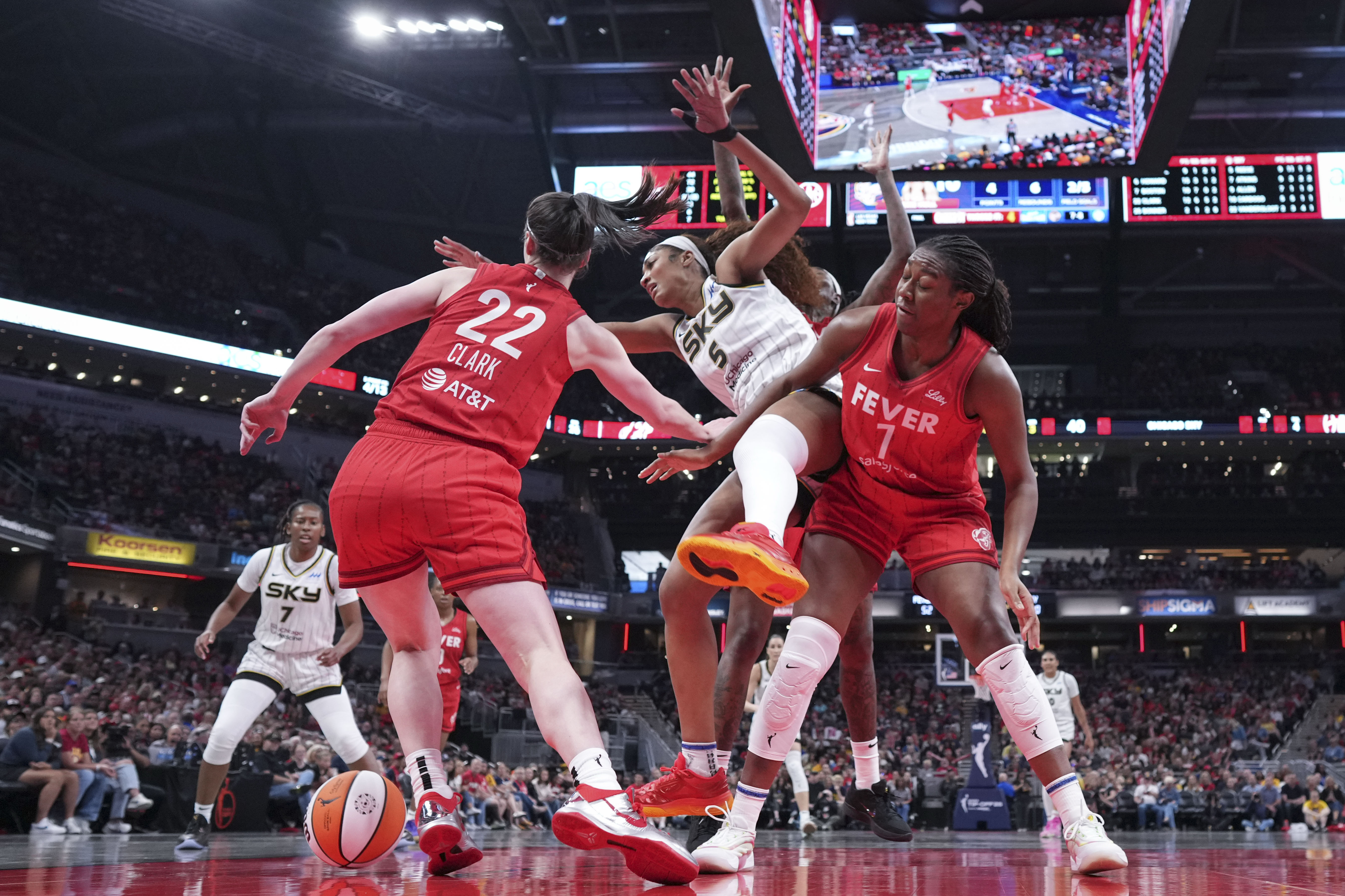 Indiana Fever guard Caitlin Clark, left, battles for the ball with Chicago Sky forward Angel Reese, center, during the second half an WNBA basketball game in Indianapolis, Saturday, May 17, 2025.