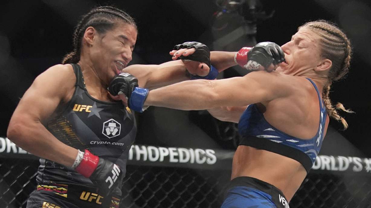 Kayla Harrison, right, exchanges punches with Julianna Peña during the second round of a women's bantamweight bout at the UFC 316 mixed martial arts event Sunday, June 8, 2025 in Newark, N.J.