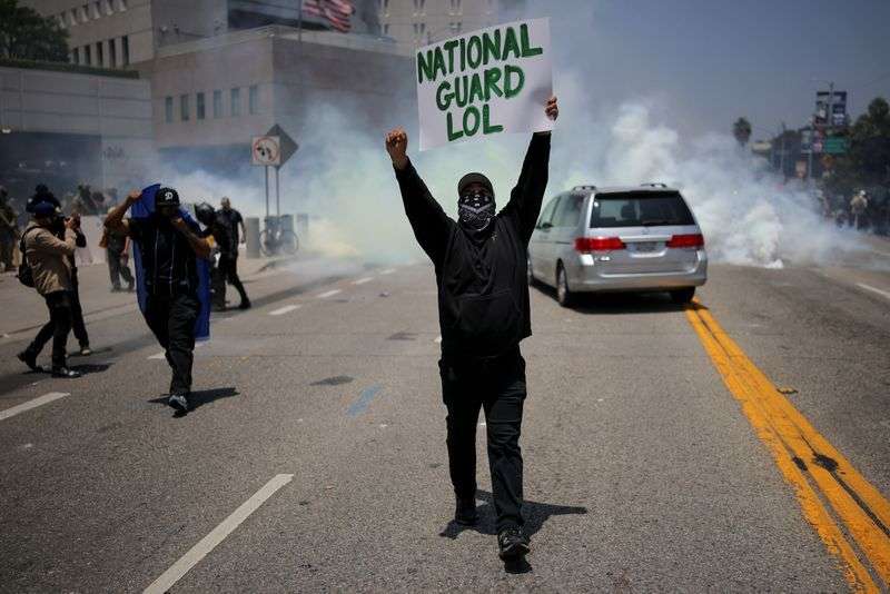 A demonstrator holds a placard during a protest against federal immigration sweeps in downtown Los Angeles, Calif., Sunday.
