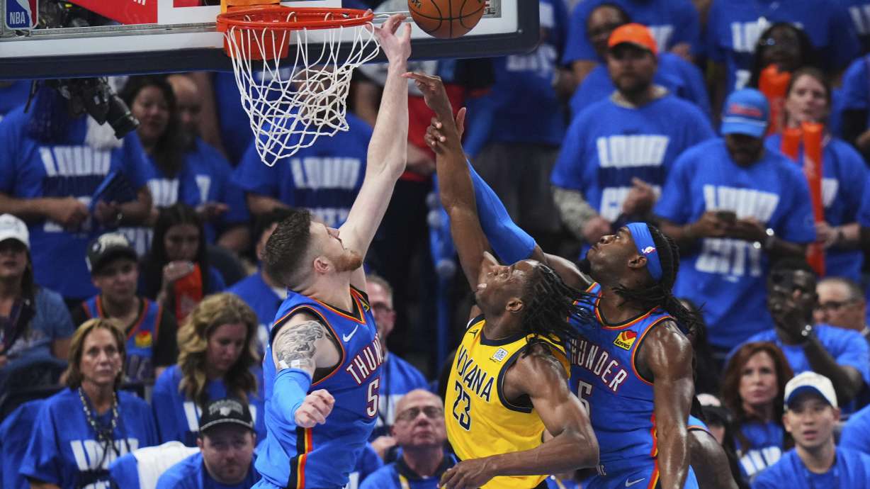 Indiana Pacers forward Aaron Nesmith (23) shoots against Oklahoma City Thunder center Isaiah Hartenstein (55) and guard Luguentz Dort (5) during the second half of Game 2 of the NBA Finals basketball series Sunday, June 8, 2025, in Oklahoma City.