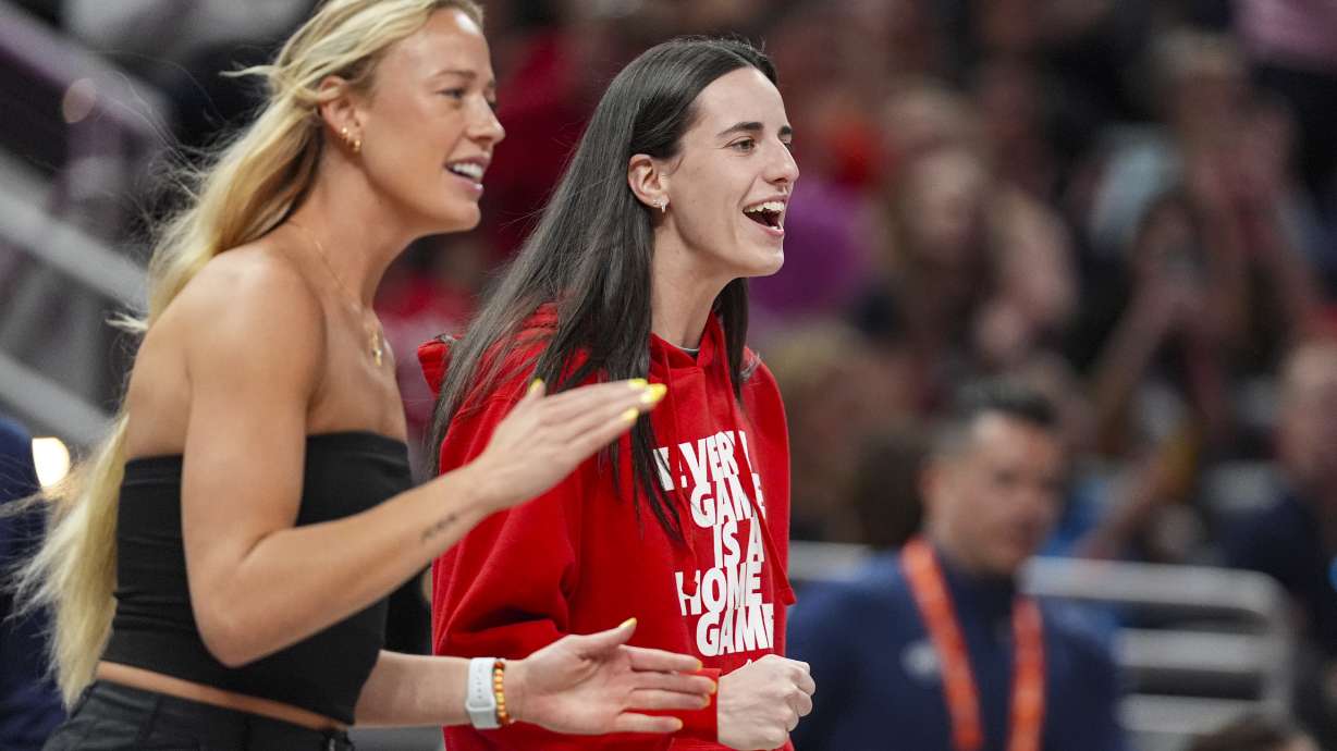 Indiana Fever guard Caitlin Clark, right, and guard Sophie Cunningham celebrates on the bench in the first half of a WNBA basketball game against the Washington Mystics in Indianapolis, Tuesday, June 3, 2025.