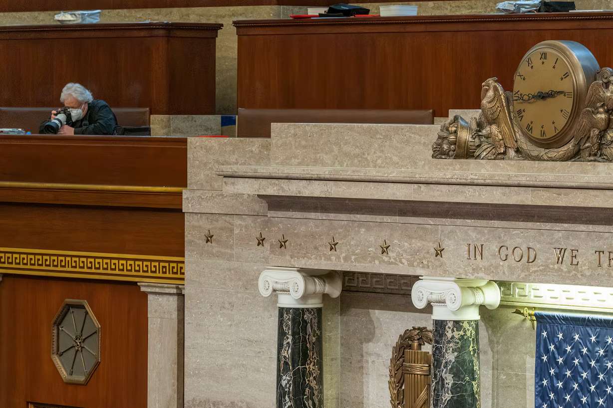 Associated Press photojournalist J. Scott Applewhite keeps his camera and lens on the doors to the U.S. House of Representatives from the press gallery at the U.S. Capitol in Washington, on Jan. 6, 2021.
