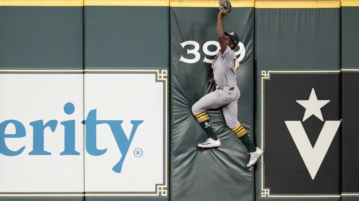 Athletics center fielder Denzel Clarke (1) tries to reach for Houston Astros' Jose Altuve's two-run home run during the fourth inning of a baseball game, Tuesday, May 27, 2025, in Houston.