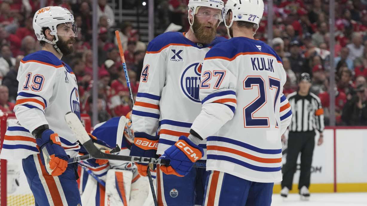 Edmonton Oilers defensemen Mattias Ekholm (14), Brett Kulak (27) and center Adam Henrique (19) talks during the second period of Game 3 of the NHL Stanley Cup final against the Florida Panthers Monday, June 9, 2025, in Sunrise, Fla.