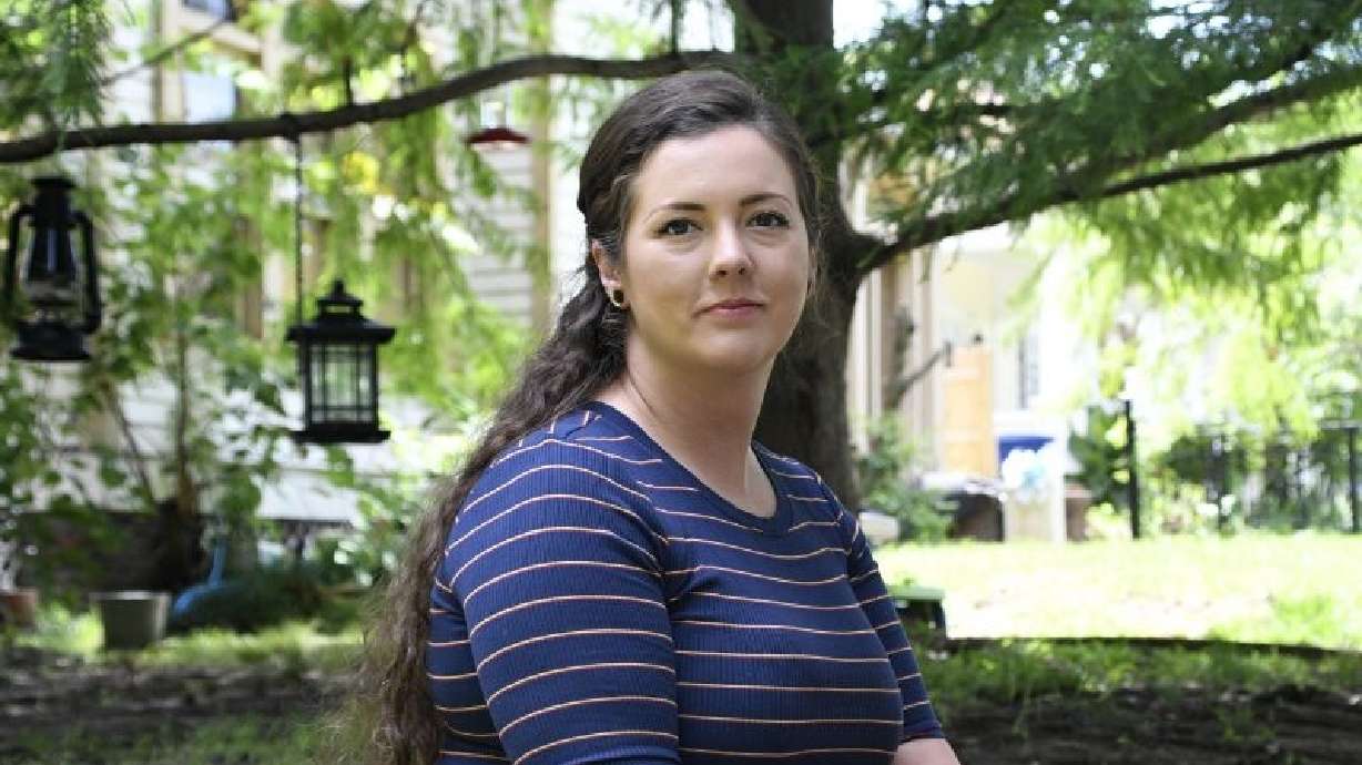 Brittnee Nelson, who runs her own housecleaning business, poses for a portrait in her neighborhood in Shreveport, La., Monday. She suffered a financial hit after student loans were taken out in her name.