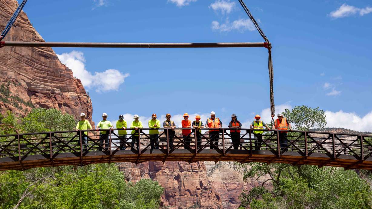 Construction crews and Zion National Park rangers stand on the Emerald Pools Bridge after it was moved onto its new foundation on May 15. The new bridge is now open, park officials said on Tuesday.
