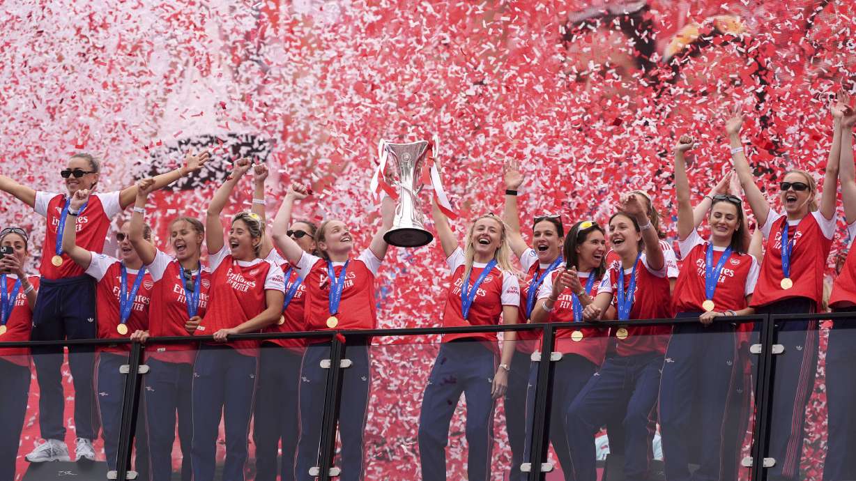 Arsenal's Kim Little and Leah Williamson hold the trophy during the Women's Champions League Winners parade in London, Monday, May 26, 2025.