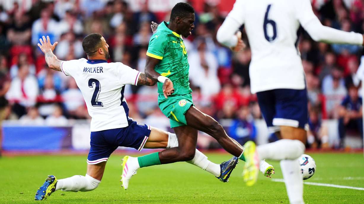 Senegal's Ismaila Sarr, center, gets free of England's Kyle Walker to score his side's first goal of the game during an international friendly match at The City Ground, in Nottingham, England, Tuesday, June 10, 2025.