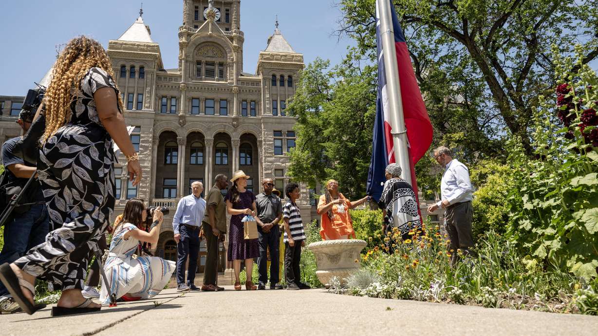 Salt Lake City's Juneteenth-themed flag is raised at an early celebration of Juneteenth at City Hall in Salt Lake City on Tuesday.