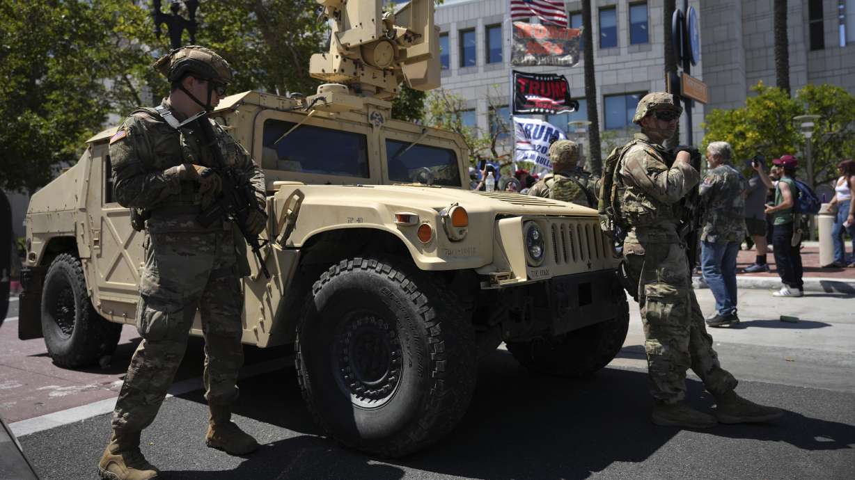 California National Guard stand guard along a street near protesters and President Donald Trump supporters in Santa Ana, Calif. on Tuesday.