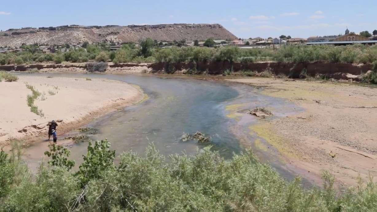 Visitors walk along the river at Zion National Park Wednesday. Park officials recently issued an advisory to visitors to not swim or submerge their heads in the water due to possible bacteria spread by algal blooms.