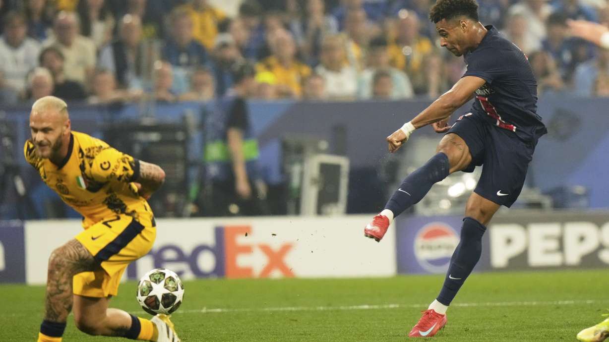 FILE - PSG's Desire Doue scores his side's second goal past Inter Milan's Federico Dimarco, left, during the Champions League final soccer match between Paris Saint-Germain and Inter Milan at the Allianz Arena in Munich, Germany, Saturday, May 31, 2025.