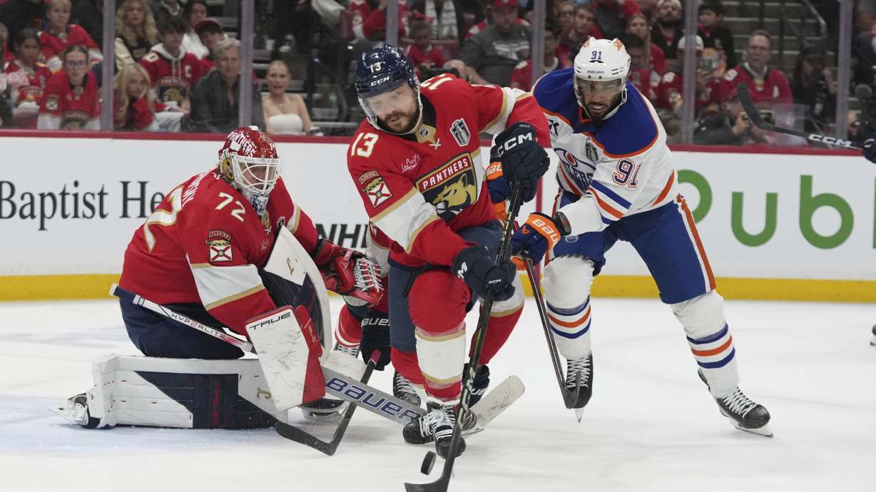 Florida Panthers center Sam Reinhart (13) hits a shot by Edmonton Oilers left wing Evander Kane (91) away from the goal during the third period of Game 3 of the NHL Stanley Cup final Monday, June 9, 2025, in Sunrise, Fla.