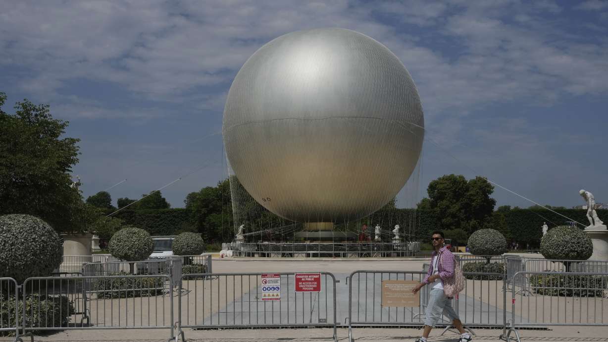 A man walks past the Olympic cauldron at the Tuileries Gardens, ahead of its nightly summer relaunch starting June 21, in Paris, Thursday, June 12, 2025.