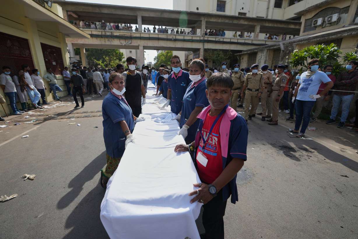 Workers of Civil Hospital wait to receive remains of victims of a plane crash in Ahmedabad, India, Thursday. Only one of the 242 passengers survived.