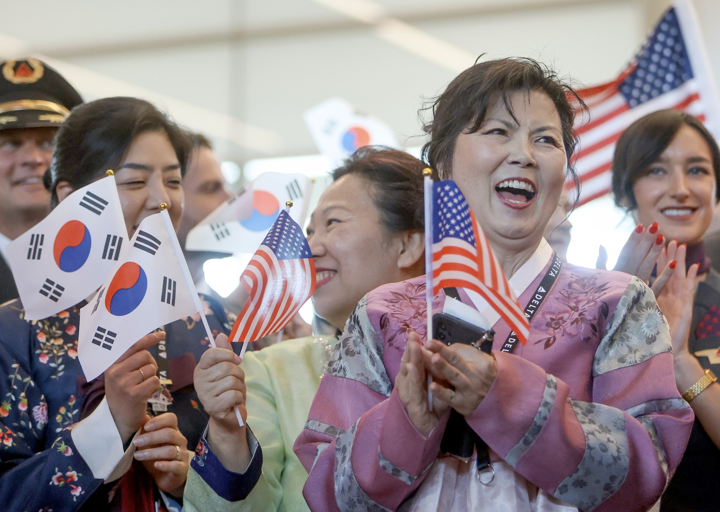 Soon-Young Campbell, Delta gate agent, applauds during a ribbon cutting ceremony for a new direct Delta flight from Salt Lake City to Incheon, South Korea, at the Salt Lake City International Airport in Salt Lake City on Thursday.