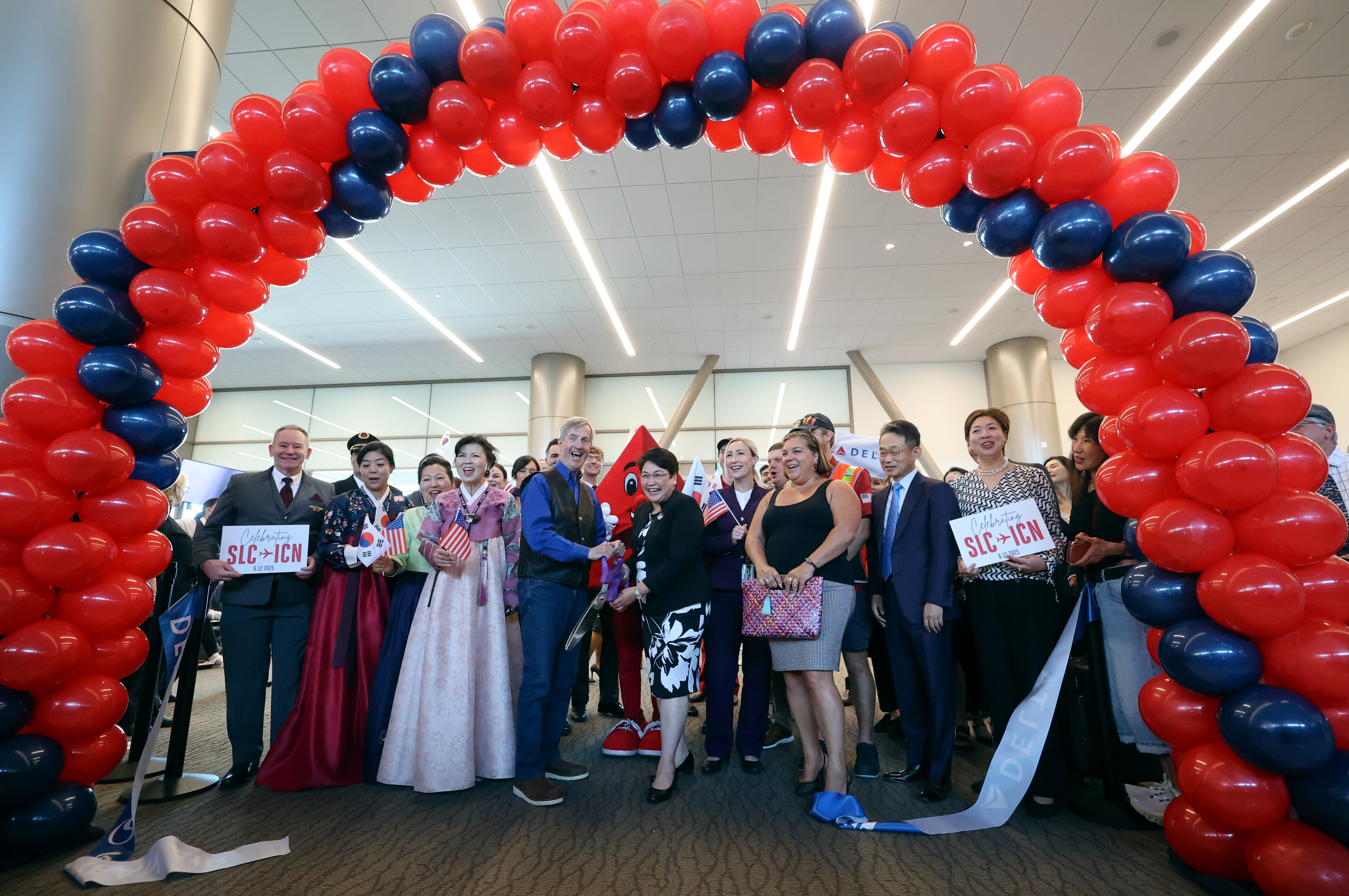 Bill Wyatt, Salt Lake City Department of Airports executive director, and Meng Aguirre, Delta Airlines managing director, cut the ceremonial ribbon at a celebration of a new direct Delta flight from Salt Lake City to Incheon, South Korea, at the Salt Lake City International Airport in Salt Lake City on Thursday.
