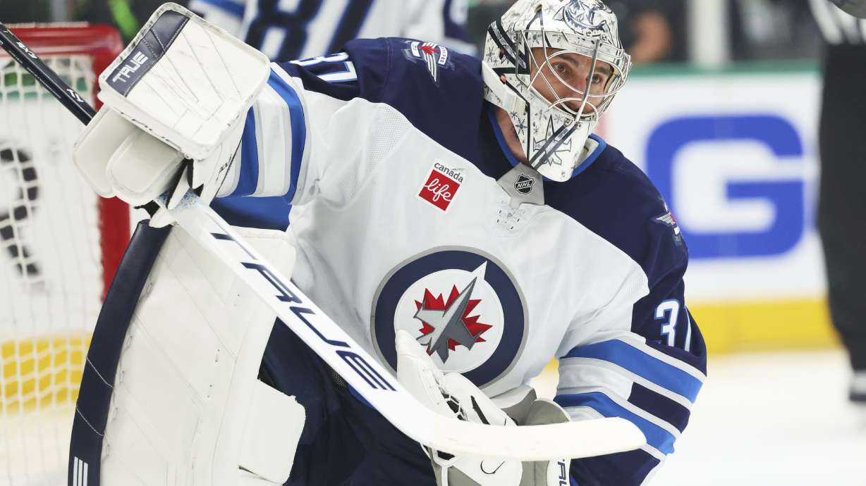 Winnipeg Jets goaltender Connor Hellebuyck recovers from making a save on a shot from the Dallas Stars in the first period of Game 6 of a second-round NHL hockey playoff series in Dallas, Saturday, May 17, 2025.