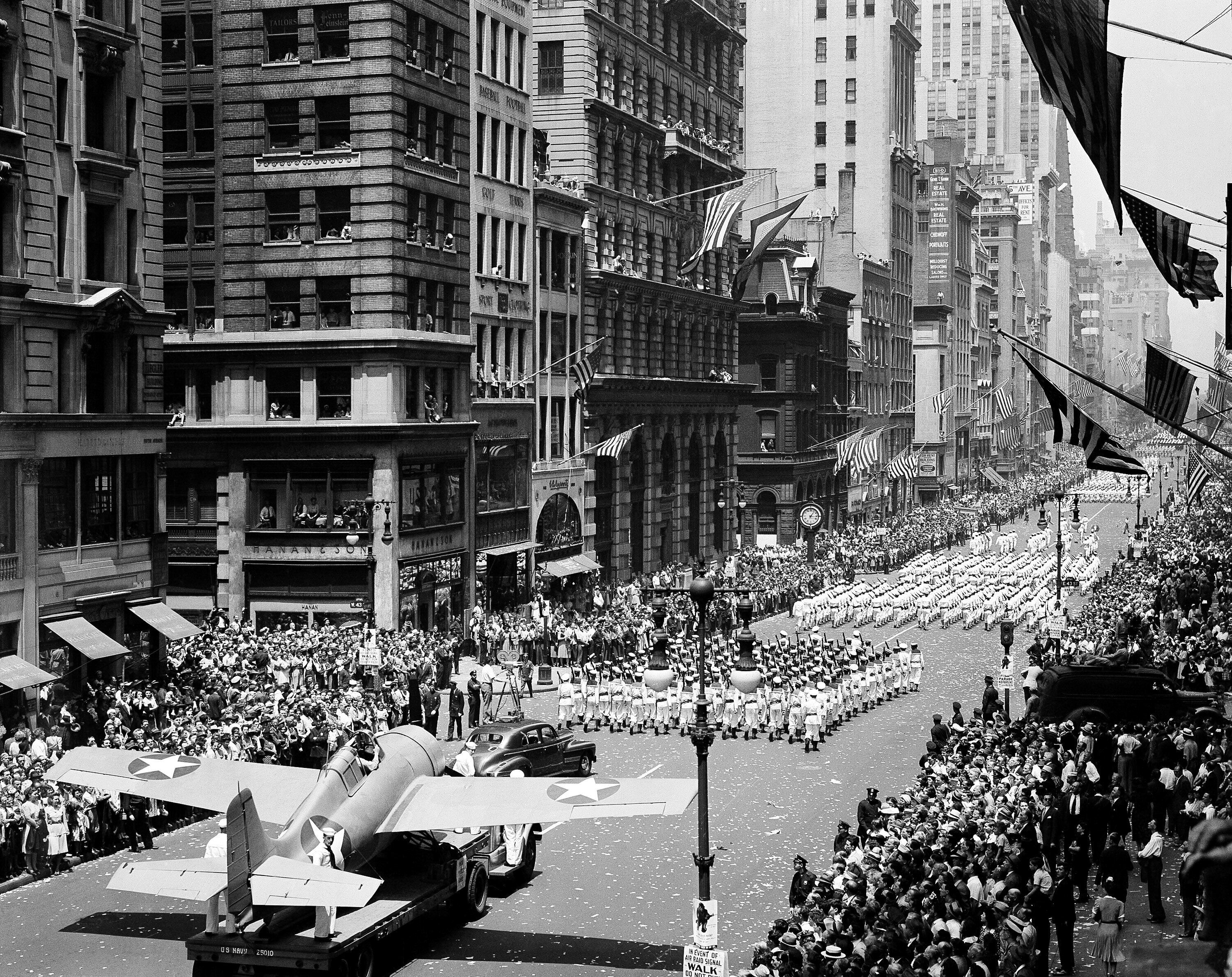 Thousands of people line the streets to cheer on naval units marching on Fifth Avenue in a war parade in New York, June 13, 1942. At lower left is a Grumman "Wildcat" fighter that is flown from U.S. aircraft carriers.