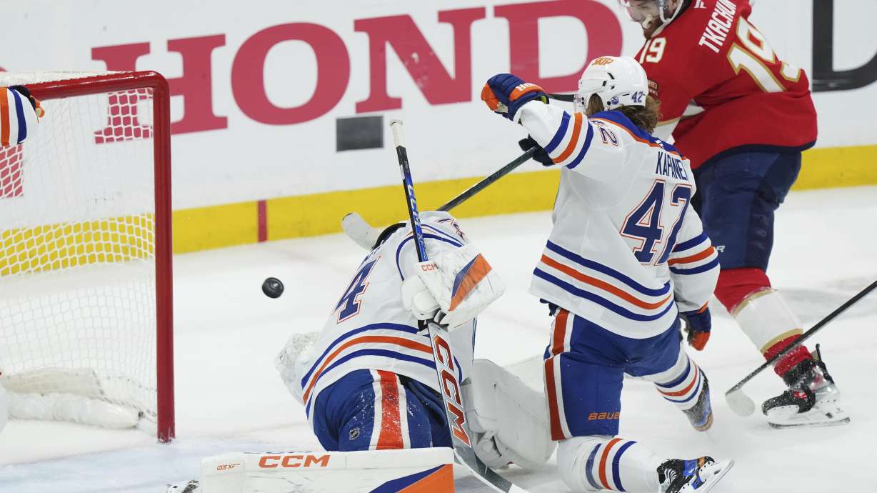 Florida Panthers' Matthew Tkachuk (19) scores against Edmonton Oilers goalie Stuart Skinner, left, as Oilers'. Kasperi Kapanen (42) defends during the first period in Game 4 of the NHL hockey Stanley Cup Final in Sunrise, Fla., Thursday, June 12, 2025.