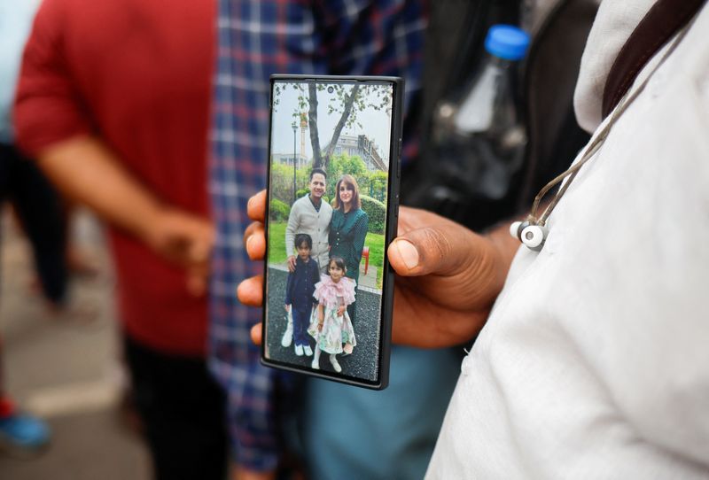 Ayyub Sheikh, 49, shows a picture of his nephew and his family, who died when an Air India Boeing 787-8 Dreamliner plane crashed during take-off from an airport in Ahmedabad, India on Friday.