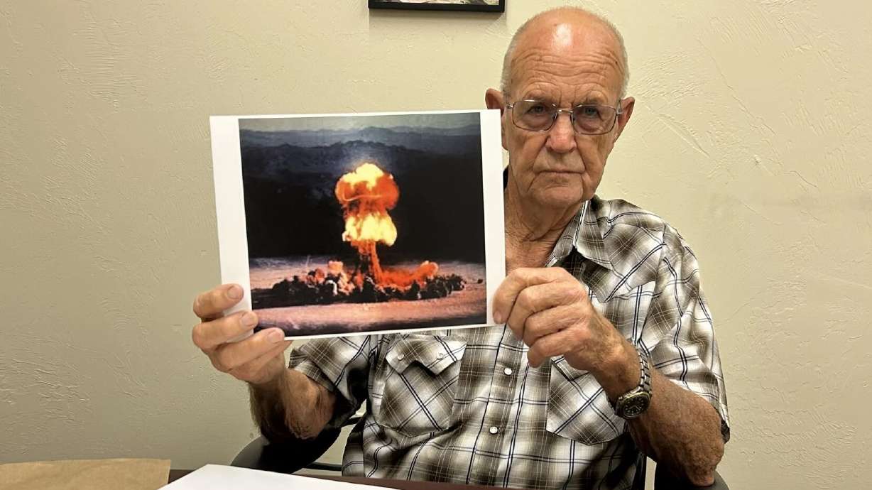 Author Eddie "Mac" Jones shows a picture of an example of the mushroom clouds he used to see while working at Area 12 when he was a young man in Nevada, St. George, June 5.
