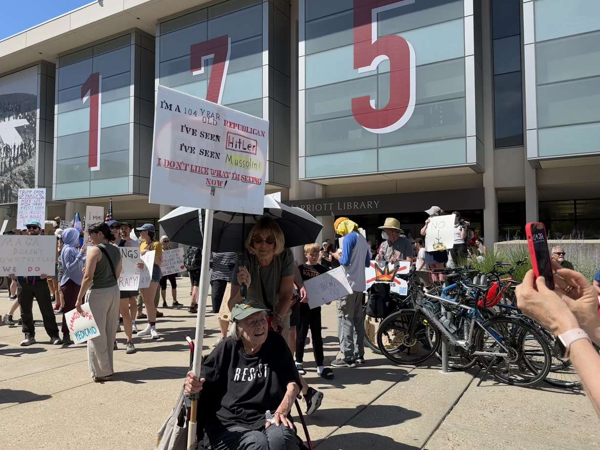 Ann McDonald, 104 years old, holds up a sign at the “No Kings” protest outside of the J. Willard Marriott Library on the campus of the University of Utah in Salt Lake City on Saturday.