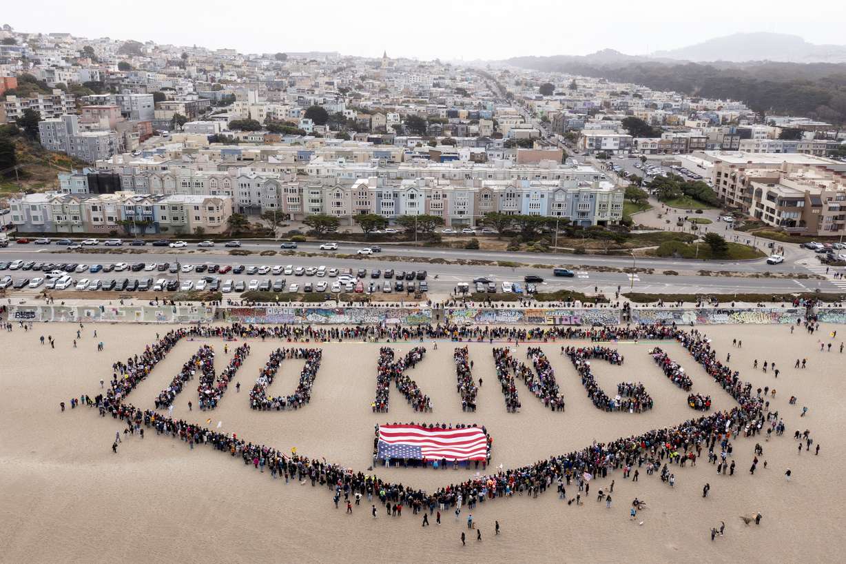 People form a human banner at Ocean Beach during the "No Kings" protests in San Francisco on Saturday. The protests were held as President Donald Trump hosted a military parade in Washington.