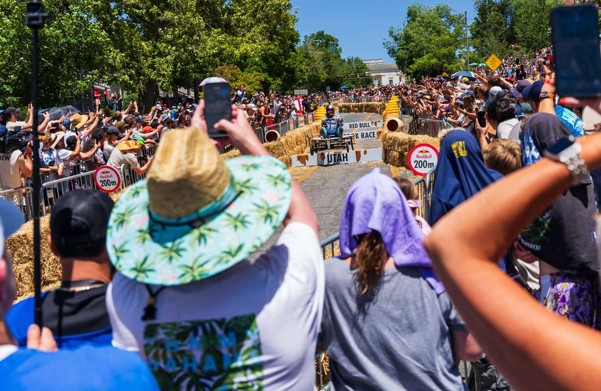 Spectators take photos as a member of "The Misguided Mystics" from Raleigh, North Carolina, makes it down the Red Bull Soapbox Race course in Salt Lake City on Saturday.