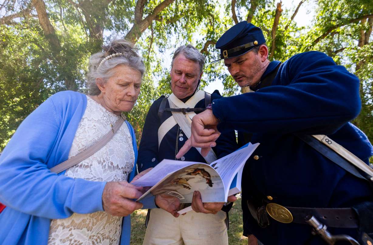 Robynn Smith-Sisam, Michael Anderson and John Cornell all look for potential ancestries of Smith-Sisam’s during a celebration of the U.S. Army’s 250th birthday at Fort Douglas in Salt Lake City on Saturday. The celebration was held as a massive military parade took place in Washington.