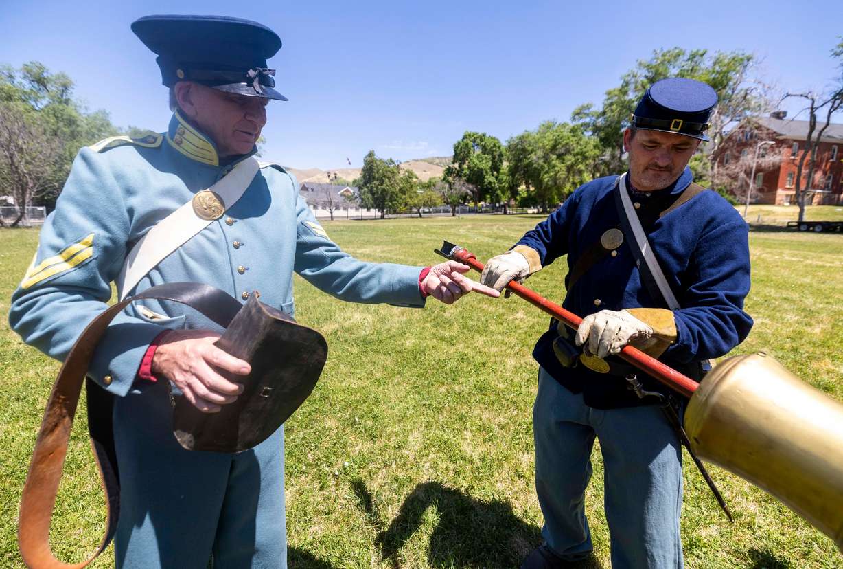 Jared Cornell and his son John Cornell clean the bore of a cannon during a celebration of the U.S. Army’s 250th birthday at Fort Douglas in Salt Lake City on Saturday. The celebration was held as a massive military parade took place in Washington.