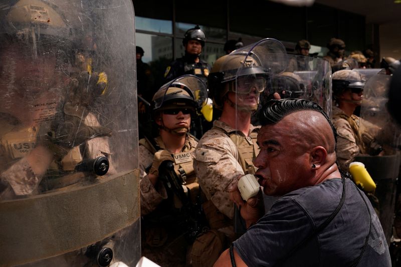Marines stand guard as people protest against President Donald Trump's policies and federal immigration sweeps during a No Kings Day demonstration in Los Angeles, Saturday. The protests came as Trump held a military parade in Washington.
