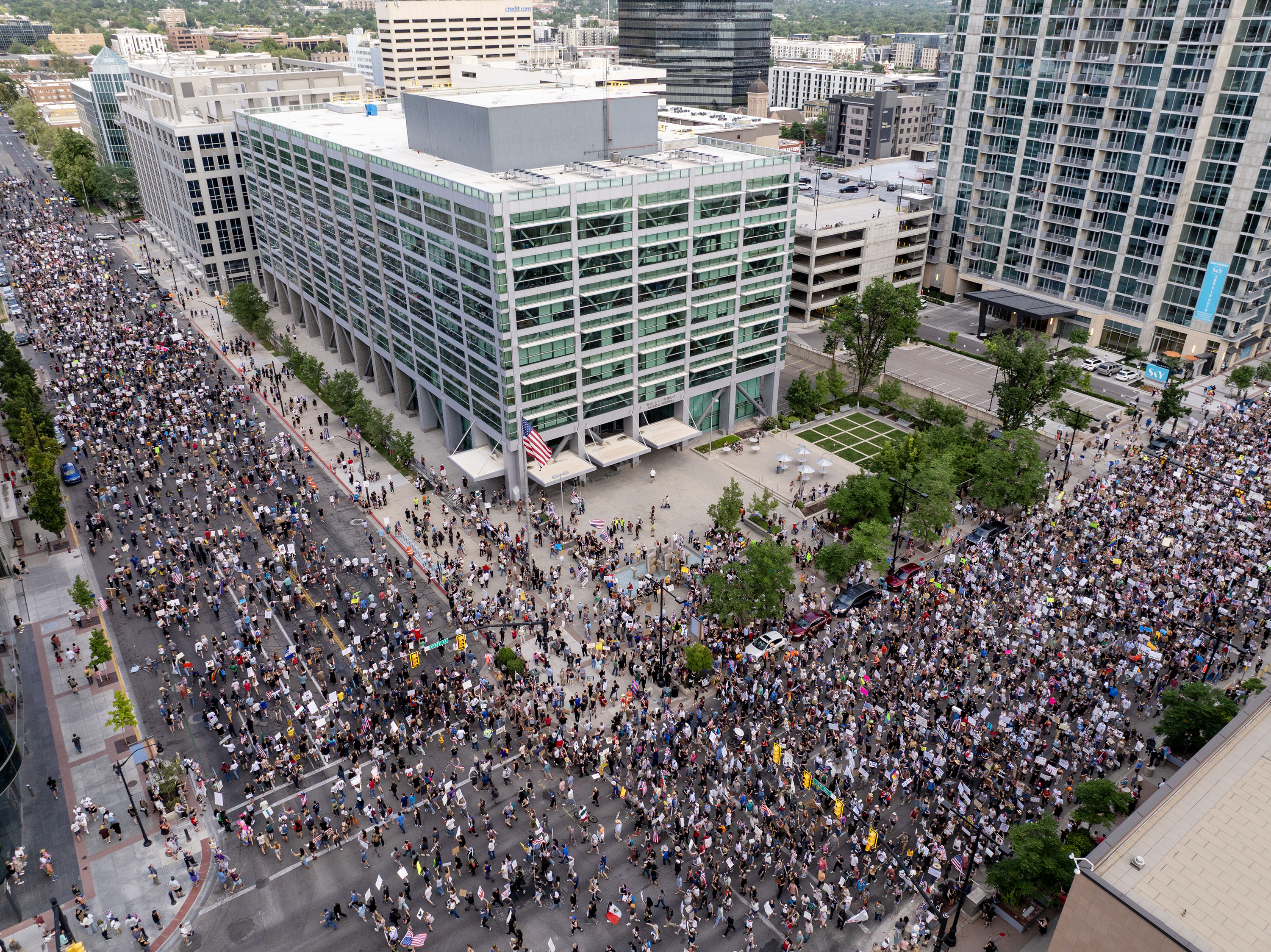 Protesters pass the Wallace F. Bennett Federal Building as they participate in a “No Kings” protest and march in Salt Lake City on Saturday.
