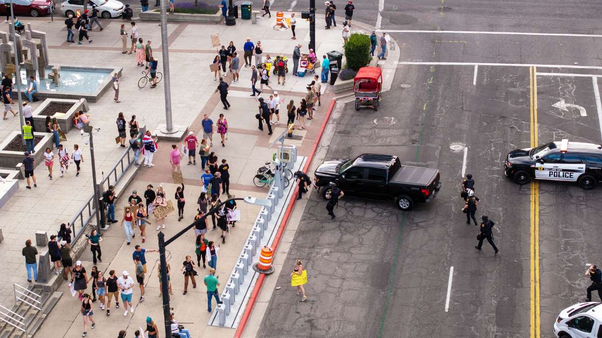 Police begin running near the Wallace F. Bennett Federal Building after reports of a shooter during the “No Kings” protest and march in Salt Lake City on June 14, 2025. A man accused of firing the shots was ordered to stand trial on Tuesday.