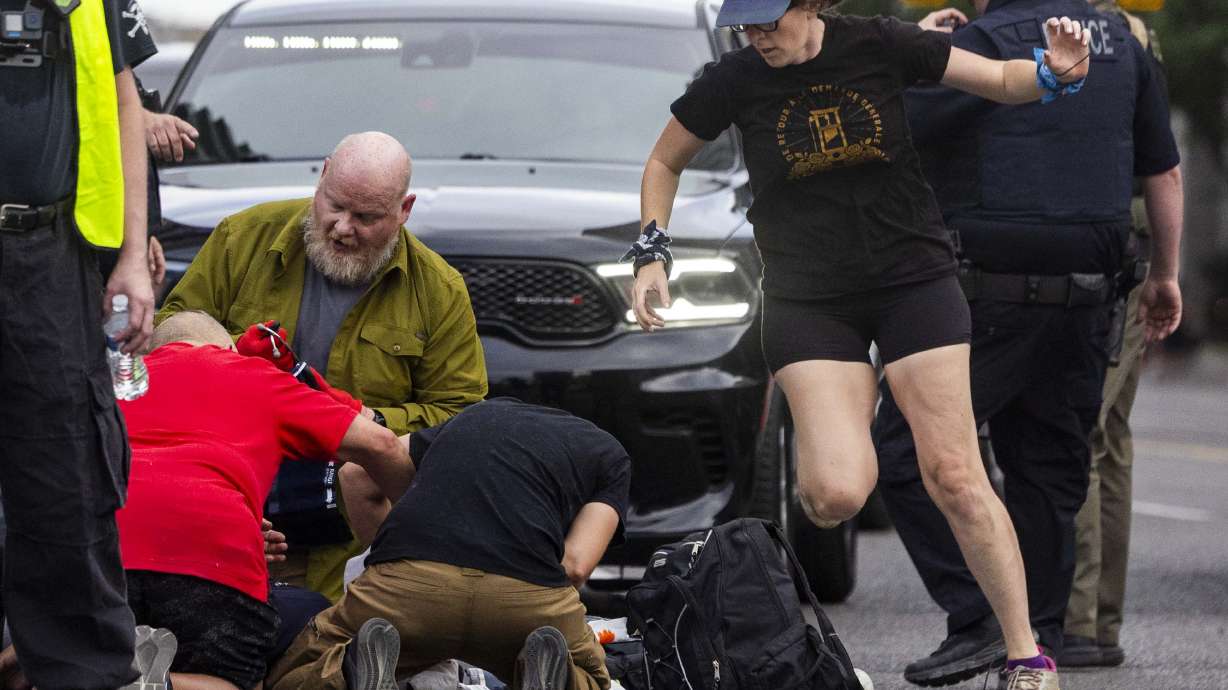 People rush to give medical assistance to a man shot during a “No Kings” protest and march in Salt Lake City on Saturday. Arthur Folasa Ah Loo, 39, died Saturday after being shot during the protest, police said.