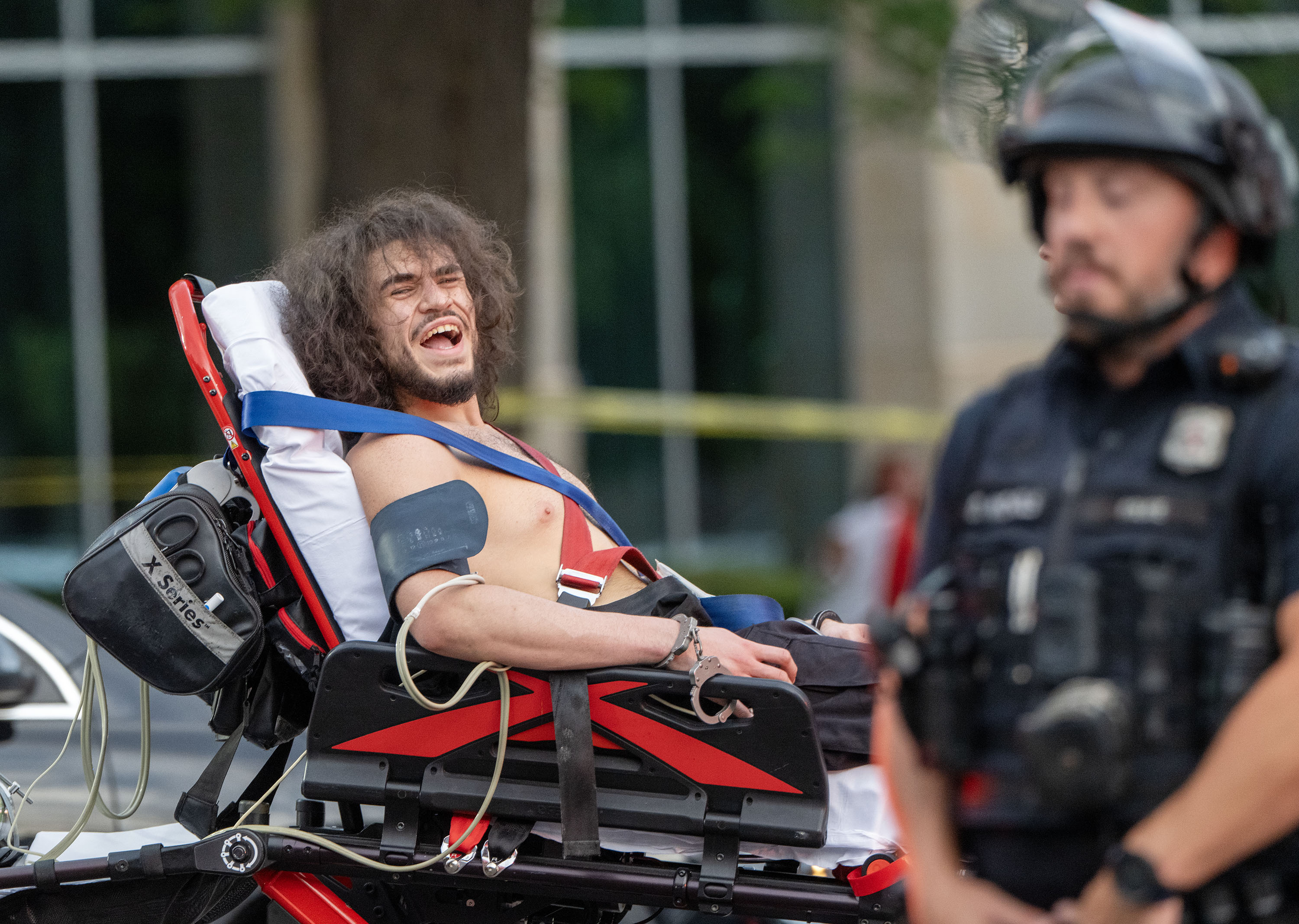 Arturo Gamboa is taken away in handcuffs on a gurney and yells that he was shot during the “No Kings” protest and march in Salt Lake City Saturday. A judge on Thursday agreed to release him from jail since no charges have been filed against him.