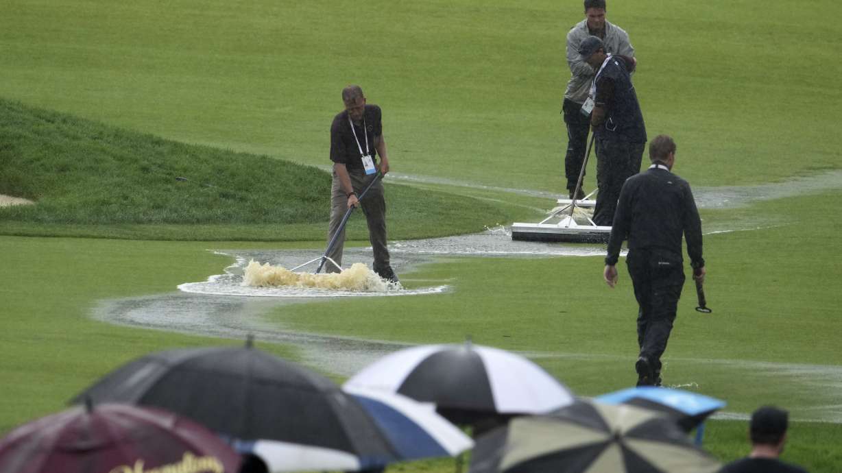 Grounds keepers clear water from the course during a weather delay in the final round of the U.S. Open golf tournament at Oakmont Country Club Sunday, June 15, 2025, in Oakmont, Pa.