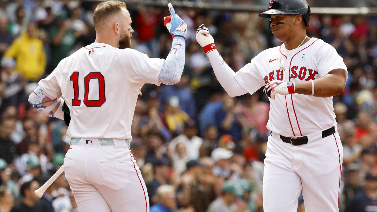 Boston Red Sox's Rafael Devers, right, celebrates with shortstop Trevor Story (10) after hitting a solo home run in the fifth inning of a baseball game against the New York Yankees, Sunday, June 15, 2025, in Boston.
