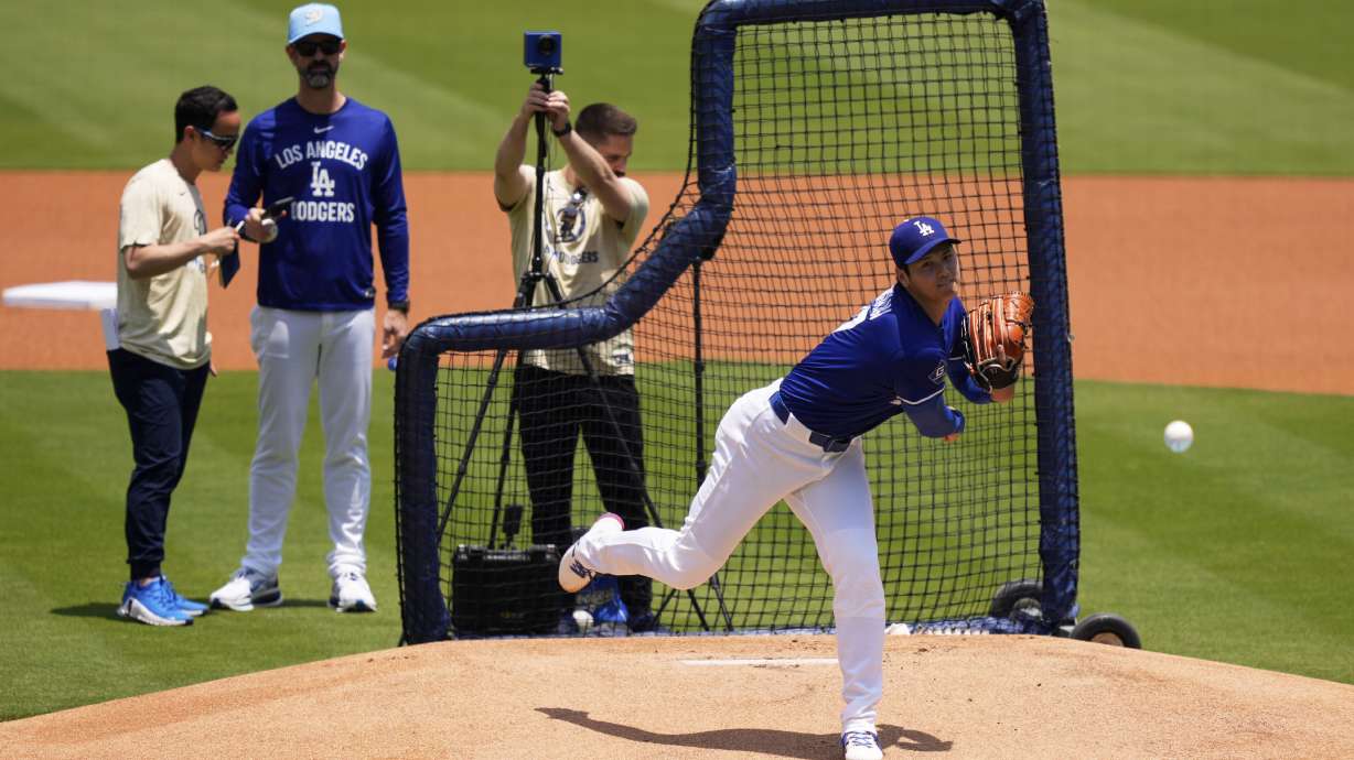 Los Angeles Dodgers' pitcher Shohei Ohtani, center, throws live batting practice as pitching coach Mark Prior, second from left, watches prior to a baseball game against the New York Yankees, Saturday, May 31, 2025, in Los Angeles.