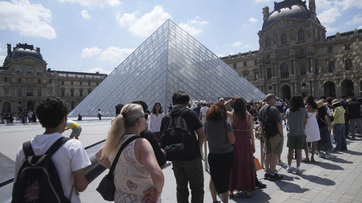 Tourists wait in line outside the Louvre museum which failed to open on time Monday in Paris. It remained shuttered most of Monday when staff went on strike.