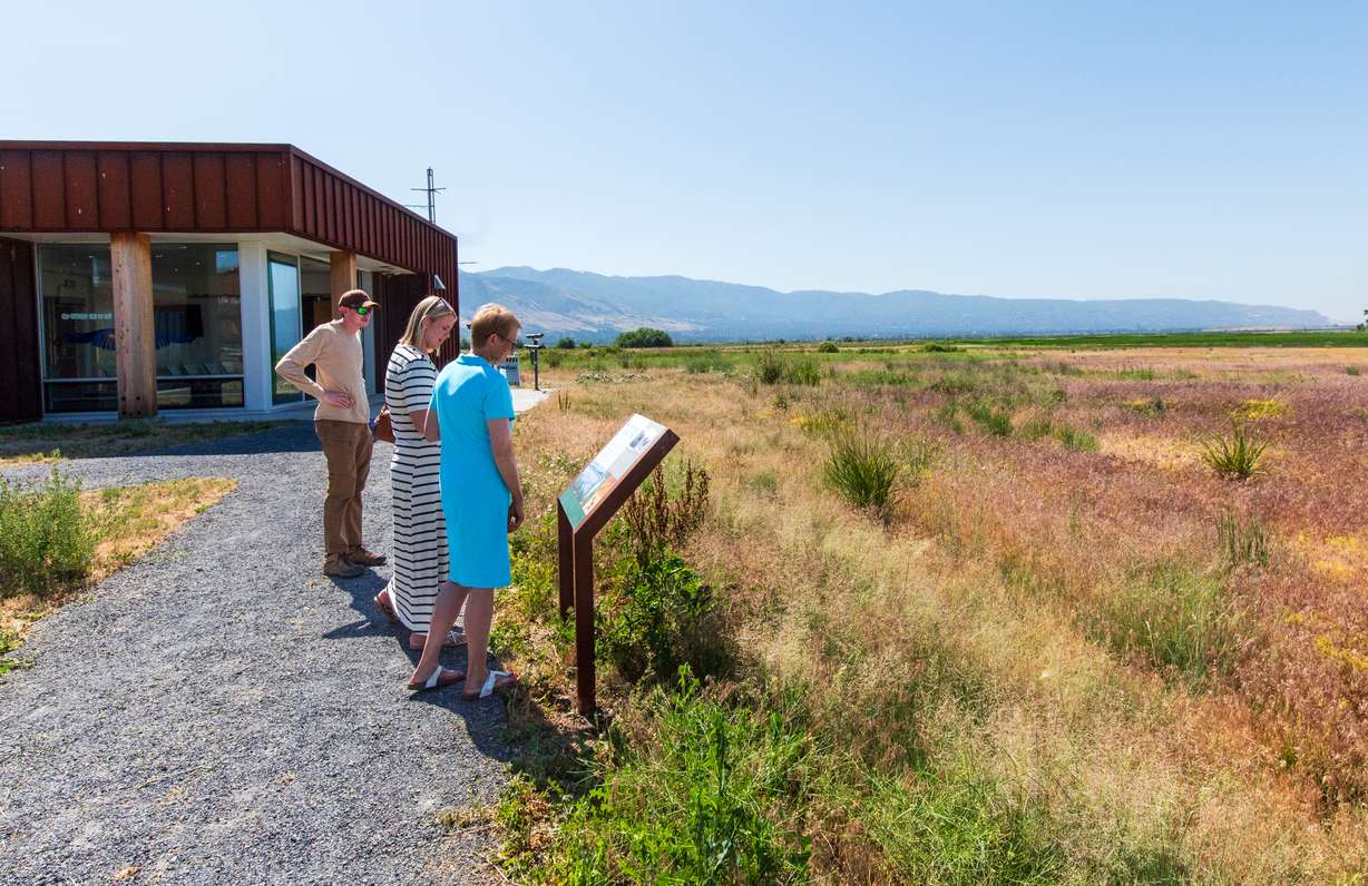 Marlene Hasenyager, farthest on right, and others read a sign educating visitors of the George S. and Dolores Doré Eccles Wildlife Education Center in Farmington about the Robert N. Hasenyager Great Salt Lake Nature Trail on Friday.
