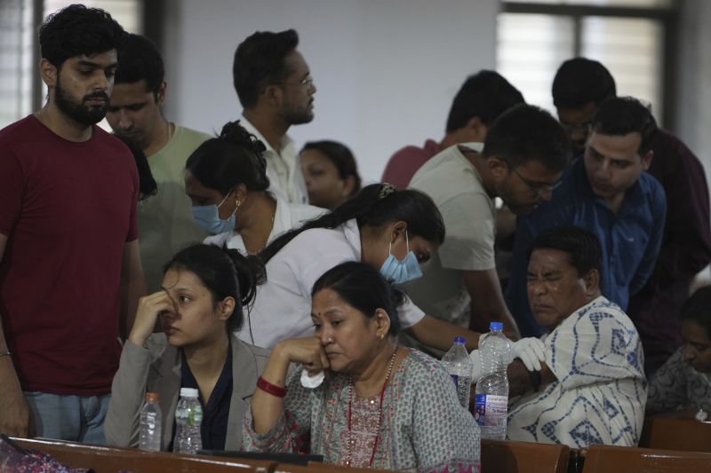 A health worker takes a DNA sample of a family member of a victim of an airplane that crashed in India's northwestern city of Ahmedabad in Gujarat state, Friday.