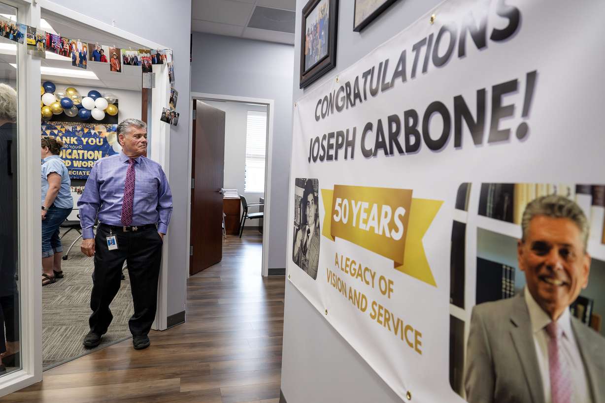 Outgoing president and CEO Joseph Carbone of EyeCare4Kids looks around at a banner and other areas during a community open house. The event celebrated leadership transitions and reintroduced the community to the organization, which has been helping children in Utah see better since 2001. It was held in Midvale on Monday.
