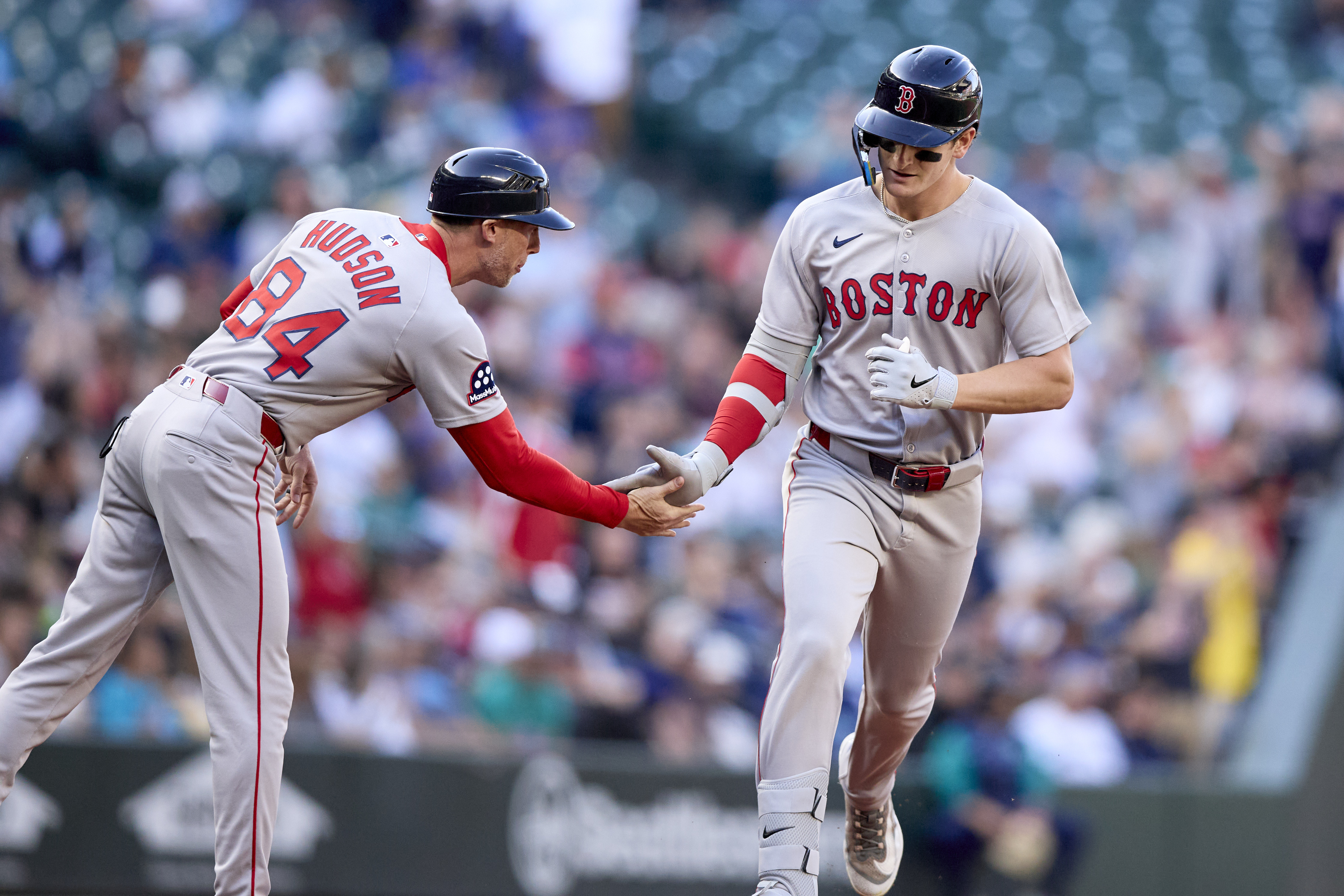 Boston Red Sox's Roman Anthony, right, is greeted by third base coach Kyle Hudson after hitting a solo home run off Seattle Mariners starting pitcher Logan Gilbert during the first inning of a baseball game Monday, June 16, 2025, in Seattle.