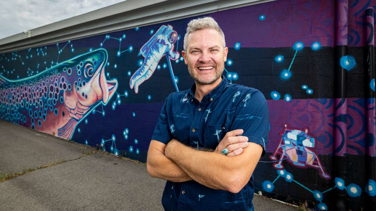 Chris Peterson in front of part of his "Space Trout and Utopia Mural Project" in Salt Lake City on June 5. A new trail map dubbed Wildlife Walls encourages people to explore Utah's biodiversity.
