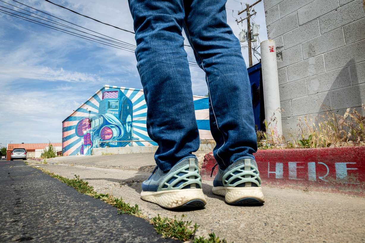 Chris Peterson stands where part of his "Space Trout and Utopia Mural Project" appears three-dimensional, in Salt Lake City on June 5. Peterson said he tries to communicate the magic of wildlife encounters in his murals.