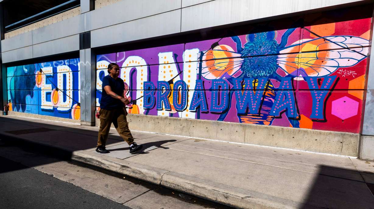 A person walks past Chris Peterson’s "Edison and Broadway" mural in Salt Lake City on June 4. Neighborhood Hive Market co-owner Jed Matthews said he recognized the opportunity to embed messages within Peterson's murals.