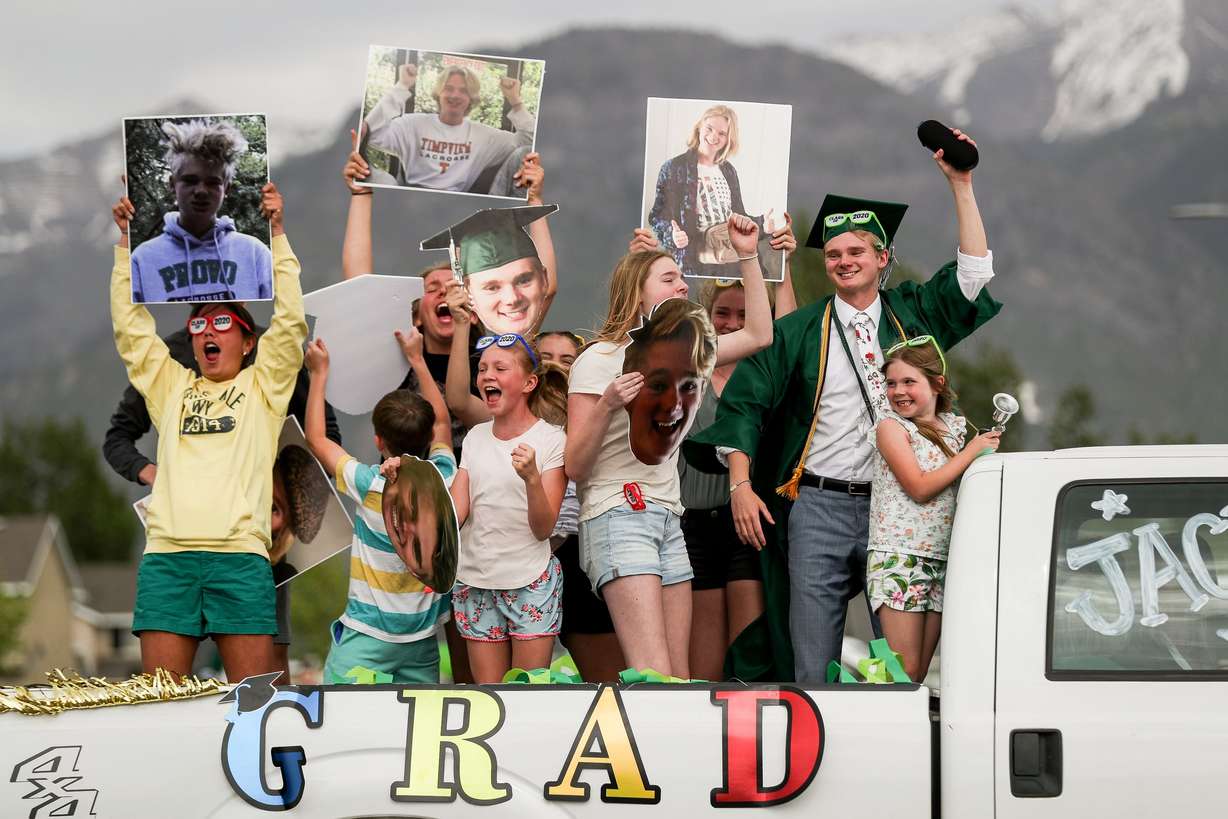 Graduate Jacy Penick, second from right, and a crowd of siblings and cousins celebrate in the back of a pickup truck during a drive-thru graduation ceremony at Provo High School on May 19, 2020.