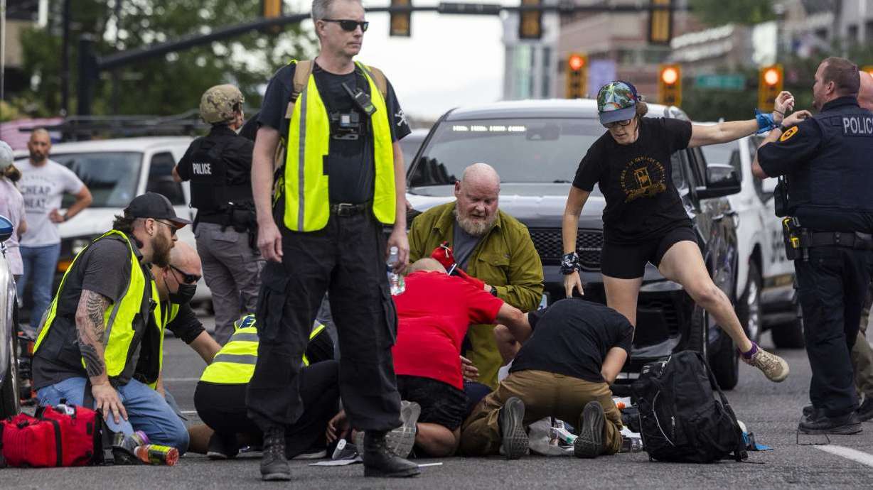 People rush to help a man shot during a No Kings protest in Salt Lake City on June 14. Salt Lake officials said Thursday they're amending the city's event permitting application process following the fatal shooting at the protest.