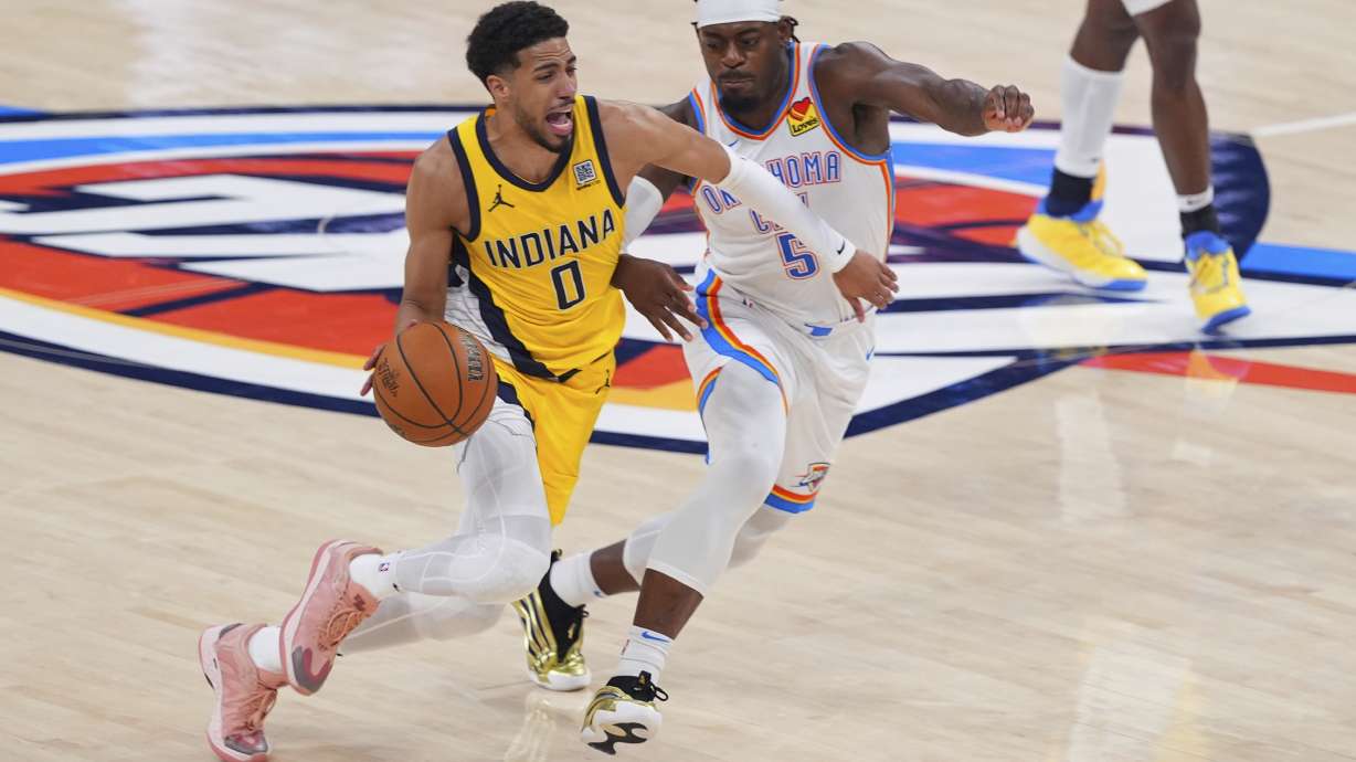 Indiana Pacers guard Tyrese Haliburton (0) drives past Oklahoma City Thunder guard Luguentz Dort (5) during the second half of Game 5 of the NBA Finals basketball series, Monday, June 16, 2025, in Oklahoma City.